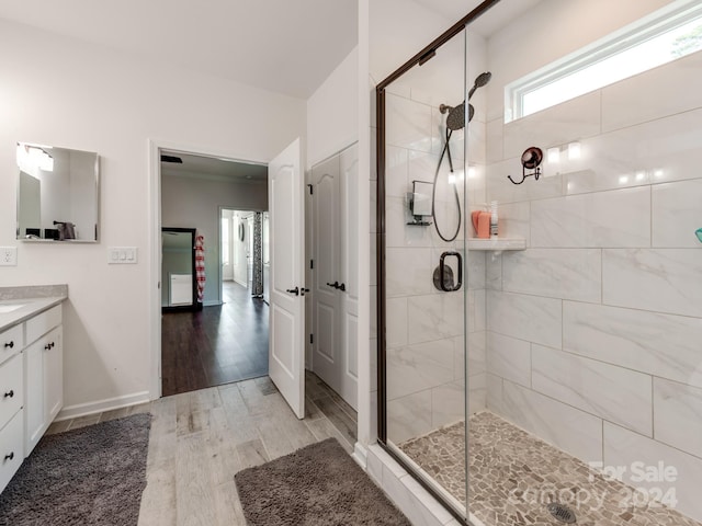 bathroom featuring a shower with door and vanity