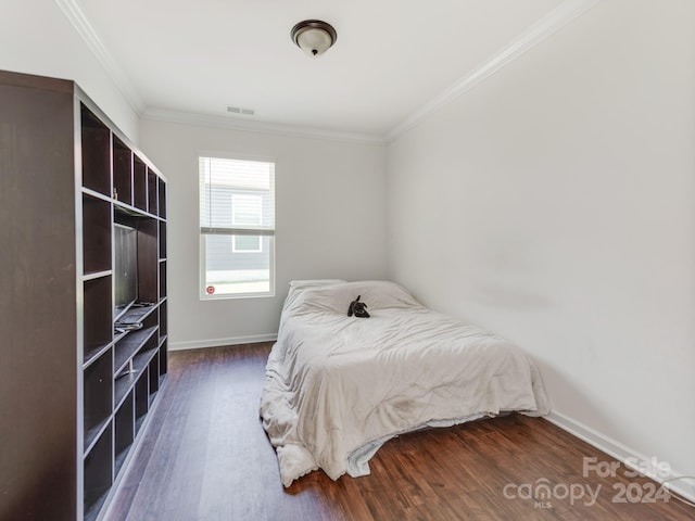 bedroom with dark wood-type flooring and crown molding