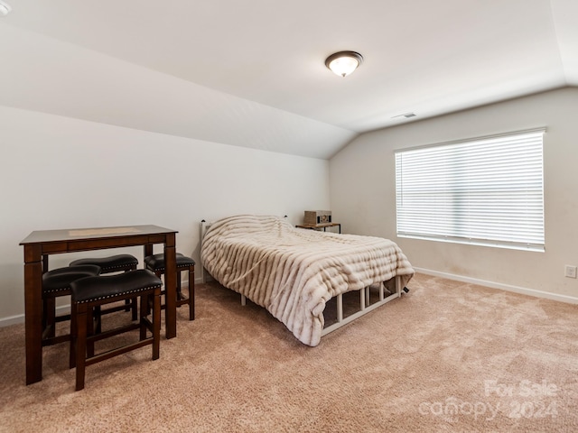 bedroom with light colored carpet and vaulted ceiling