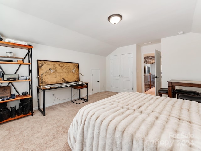 bedroom with light carpet, a closet, and vaulted ceiling