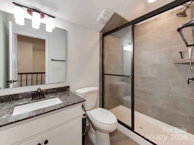 bathroom featuring walk in shower, vanity, and toilet