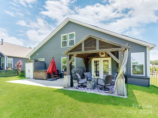 back of property with a lawn, a shed, a hot tub, and a patio