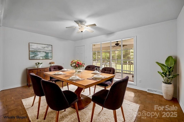 dining space featuring ceiling fan and dark parquet floors