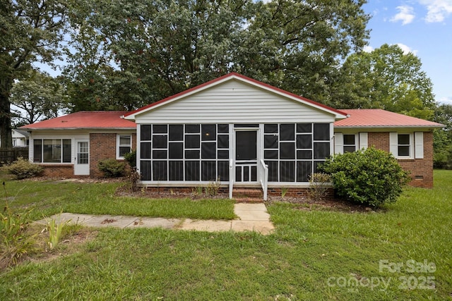 view of front of house with a sunroom and a front lawn