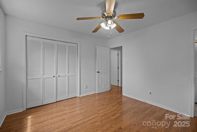 unfurnished bedroom featuring ceiling fan, light hardwood / wood-style floors, and a closet