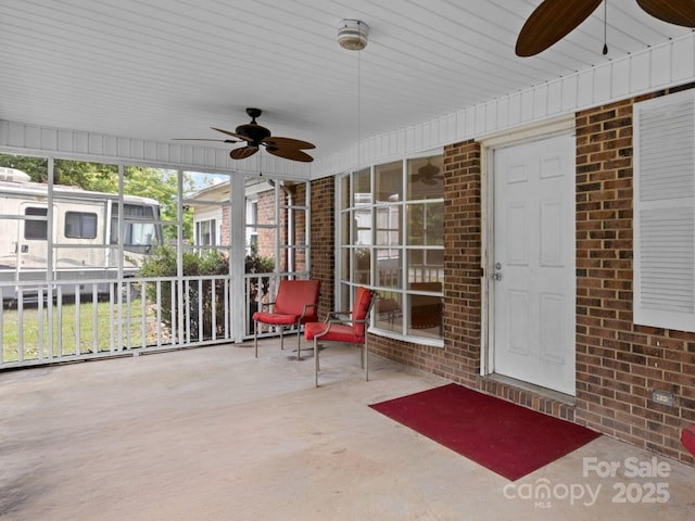 unfurnished sunroom featuring ceiling fan