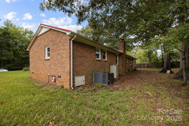 view of side of home with a lawn and central air condition unit