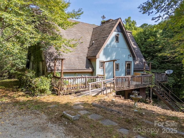 rear view of house featuring a wooden deck