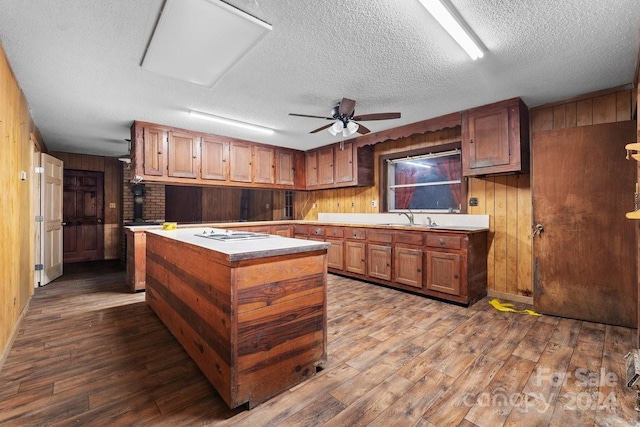 kitchen with wooden walls, hardwood / wood-style floors, and a textured ceiling