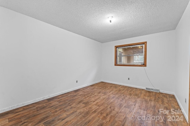 empty room featuring hardwood / wood-style floors and a textured ceiling