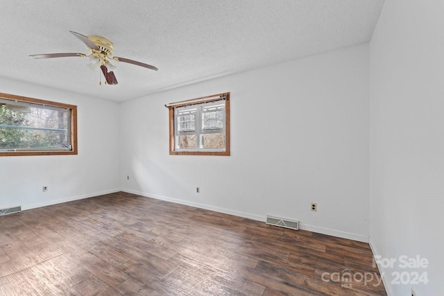 empty room with ceiling fan, a textured ceiling, and dark wood-type flooring