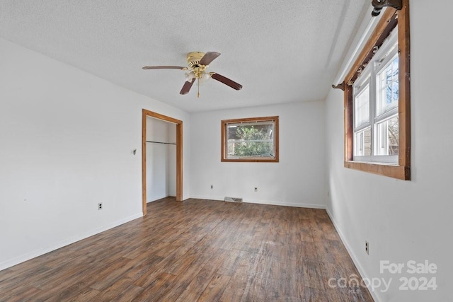 unfurnished bedroom featuring ceiling fan, dark hardwood / wood-style flooring, and a textured ceiling