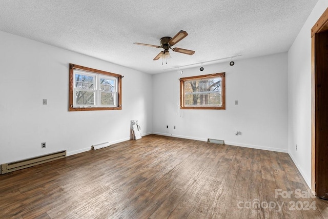 spare room with dark hardwood / wood-style flooring, a textured ceiling, baseboard heating, and ceiling fan