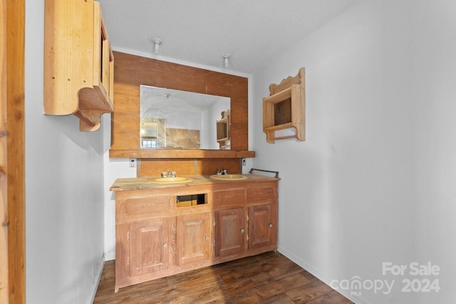 bar featuring dark hardwood / wood-style flooring, a textured ceiling, and sink