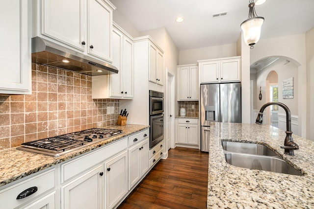 kitchen with decorative backsplash, stainless steel appliances, sink, pendant lighting, and white cabinetry