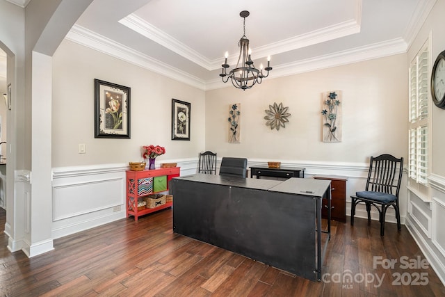 office space with a notable chandelier, a raised ceiling, crown molding, and dark wood-type flooring