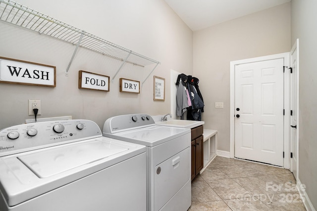 clothes washing area with cabinets, independent washer and dryer, sink, and light tile patterned flooring