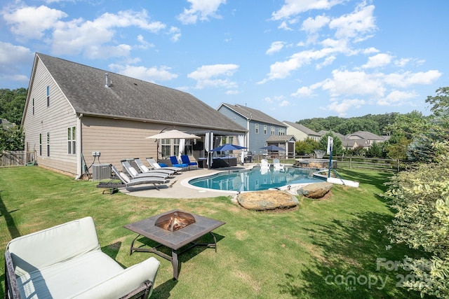 view of swimming pool with a patio, a yard, central AC unit, and an outdoor living space with a fire pit