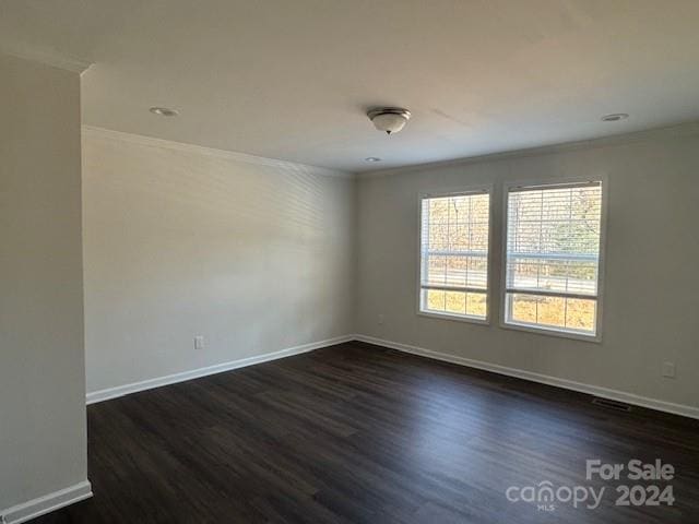 unfurnished room with dark hardwood / wood-style floors and crown molding