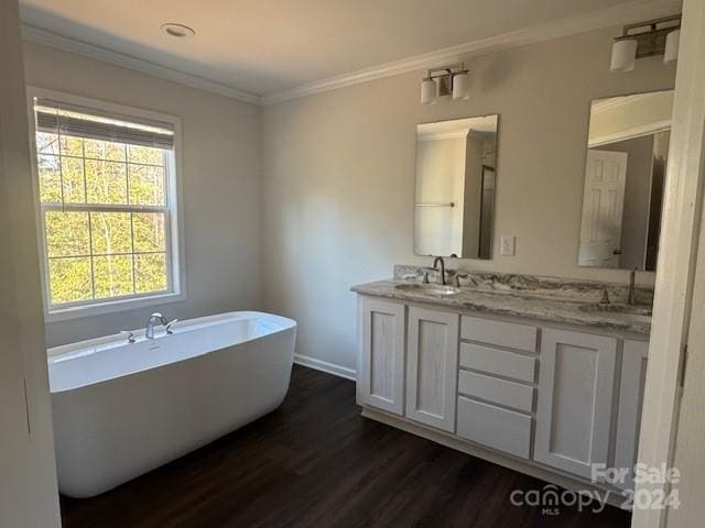 bathroom featuring hardwood / wood-style floors, vanity, a bathtub, and crown molding