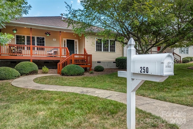 view of front of house with a front yard and a deck