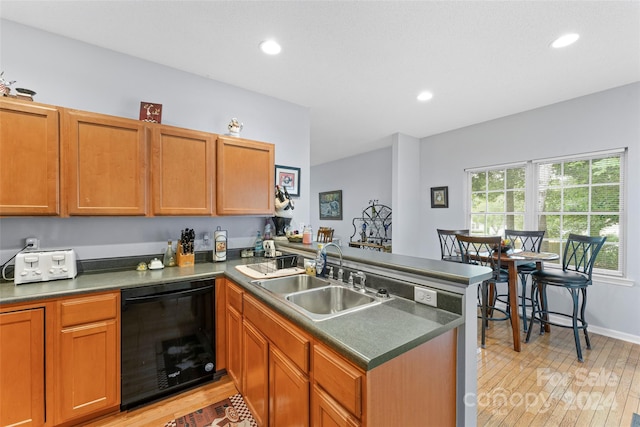 kitchen with kitchen peninsula, dishwasher, sink, and light hardwood / wood-style flooring