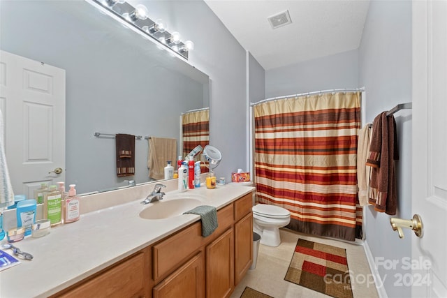 bathroom with a textured ceiling, toilet, vanity, and walk in shower