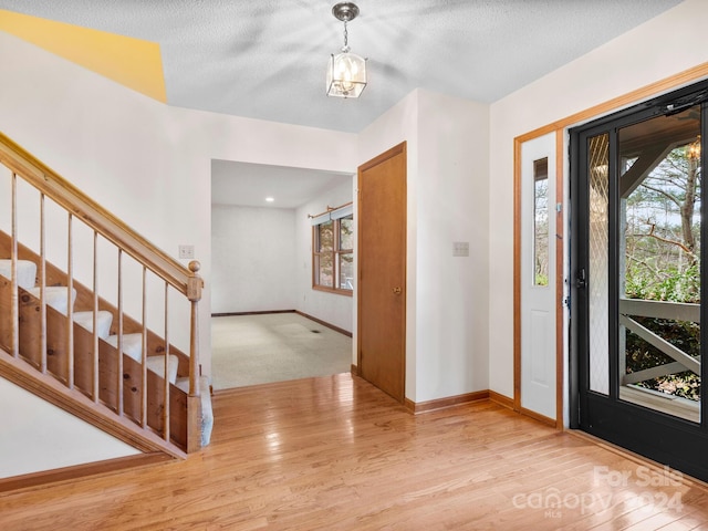 entrance foyer featuring a textured ceiling and light hardwood / wood-style floors