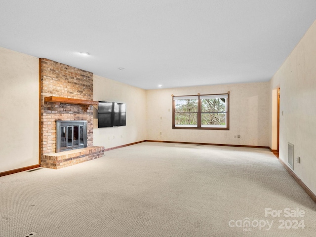 unfurnished living room featuring light colored carpet and a brick fireplace