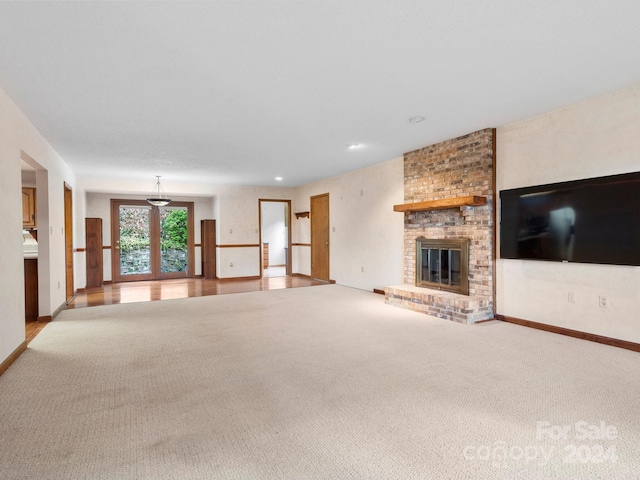 unfurnished living room with light colored carpet and a fireplace