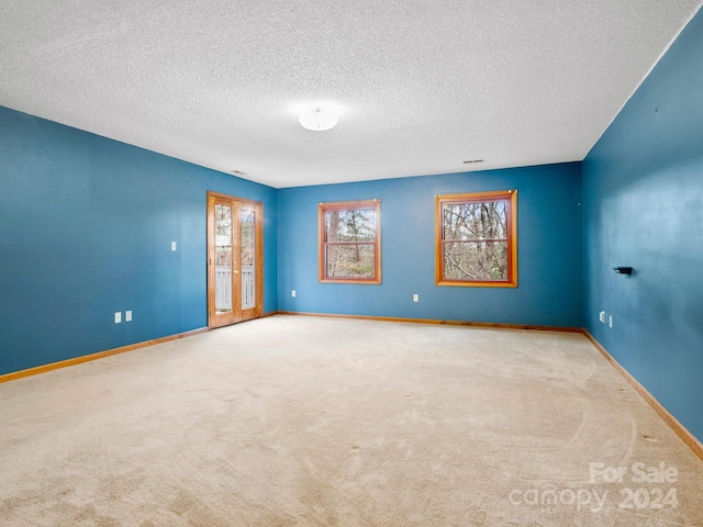 carpeted spare room featuring a textured ceiling