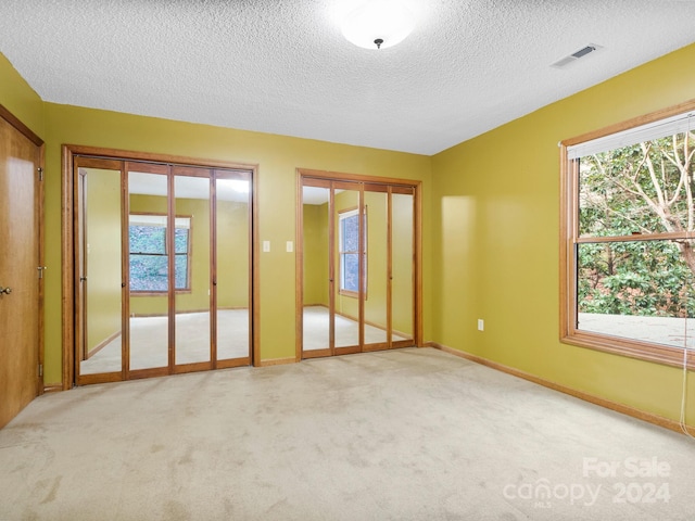 carpeted spare room with a textured ceiling