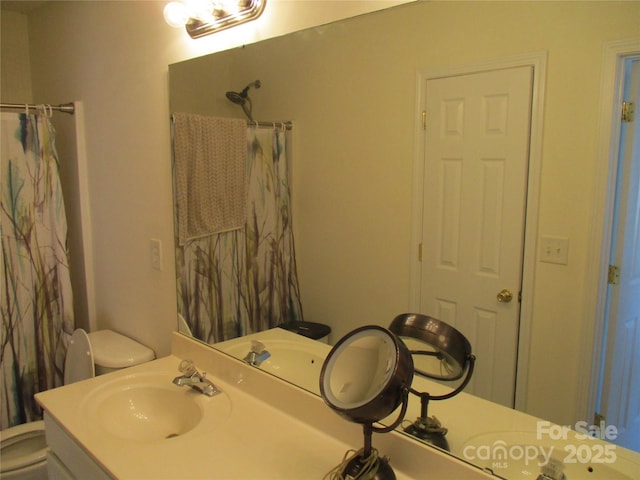 bathroom featuring walk in shower, vanity, and toilet