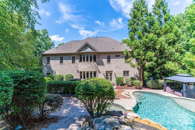 back of property featuring a gazebo and a patio