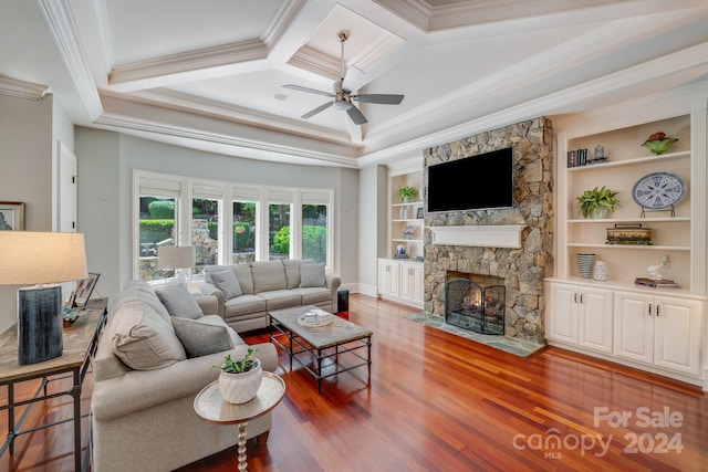 living room featuring crown molding, a fireplace, coffered ceiling, and built in shelves