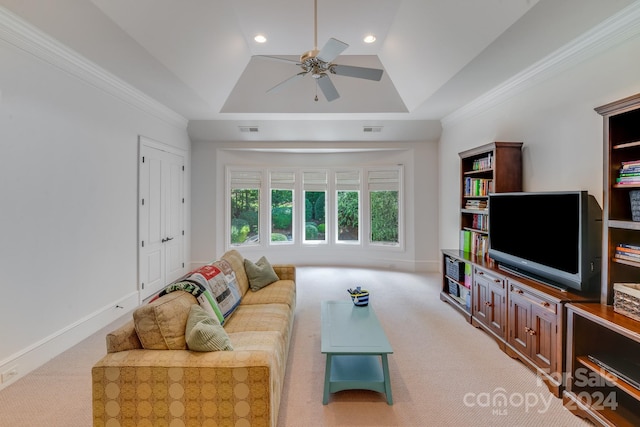 carpeted living room with ceiling fan, a tray ceiling, and crown molding