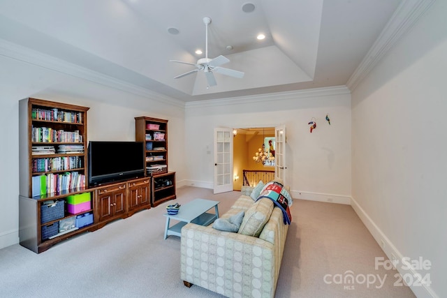 living area featuring baseboards, ornamental molding, a tray ceiling, french doors, and carpet floors