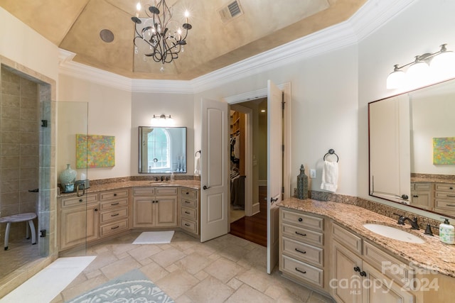 bathroom with vanity, a chandelier, crown molding, and a tray ceiling