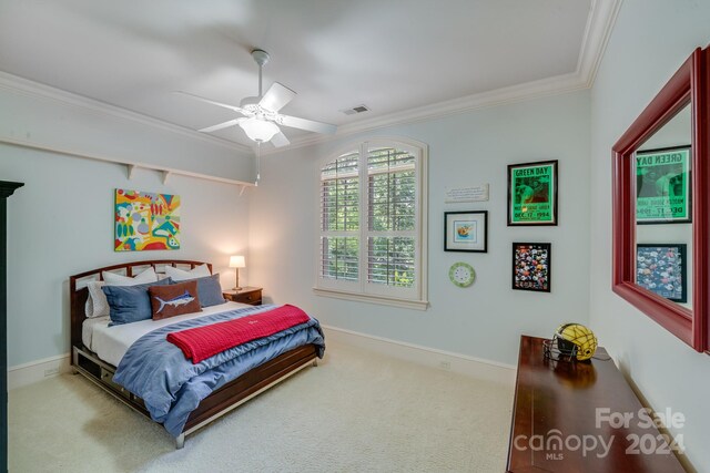 bedroom with ceiling fan, light colored carpet, and crown molding