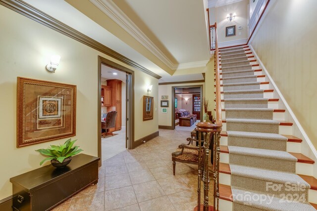 interior space with ornamental molding, tile patterned flooring, and baseboards