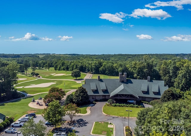 drone / aerial view featuring golf course view and a wooded view