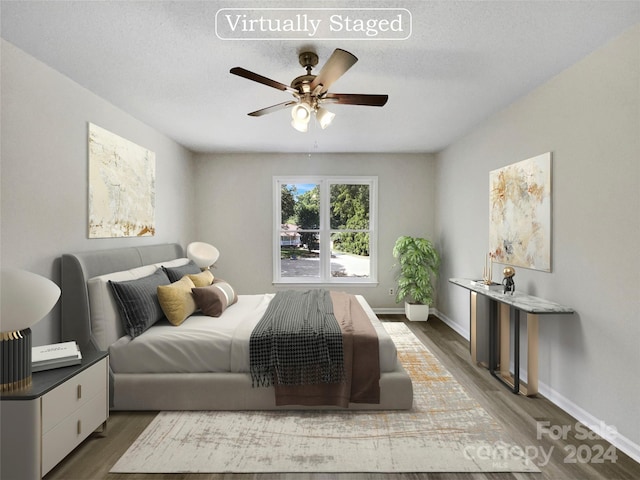 bedroom with a textured ceiling, ceiling fan, and wood-type flooring