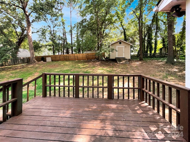 wooden deck with a storage unit and a lawn