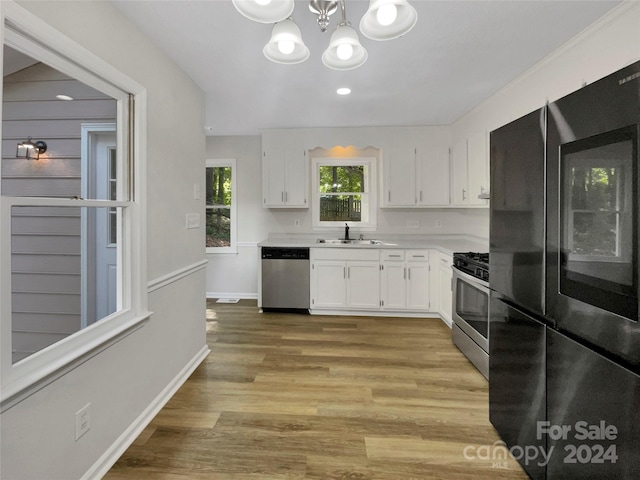 kitchen featuring light hardwood / wood-style flooring, stainless steel appliances, a notable chandelier, white cabinets, and sink