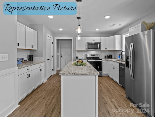 kitchen with tasteful backsplash, a center island, sink, white cabinetry, and appliances with stainless steel finishes