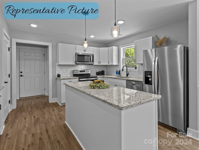 kitchen featuring white cabinetry, sink, stainless steel appliances, and a center island