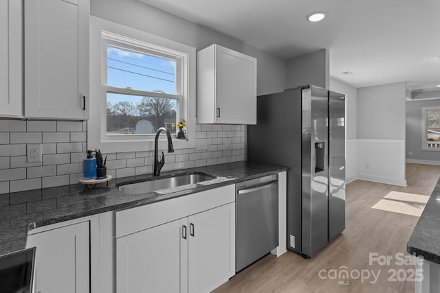 kitchen featuring white cabinetry, sink, stainless steel appliances, and light wood-type flooring