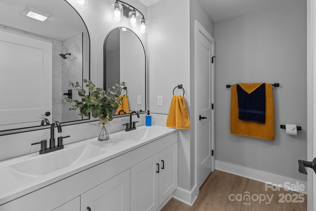 bathroom with vanity, hardwood / wood-style floors, and a tile shower