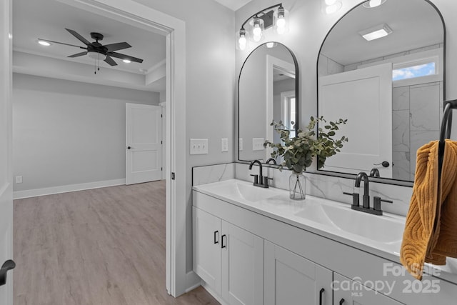 bathroom featuring crown molding, vanity, a tray ceiling, ceiling fan, and hardwood / wood-style floors