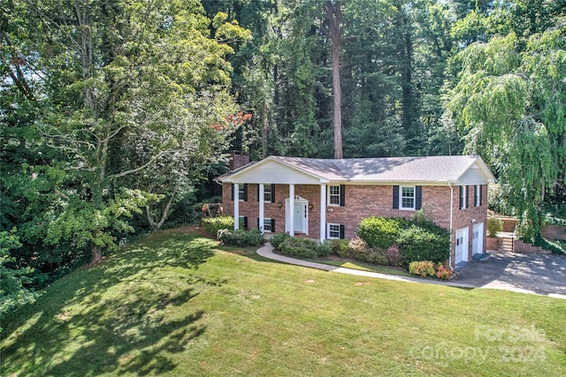 bi-level home with a garage and a front lawn